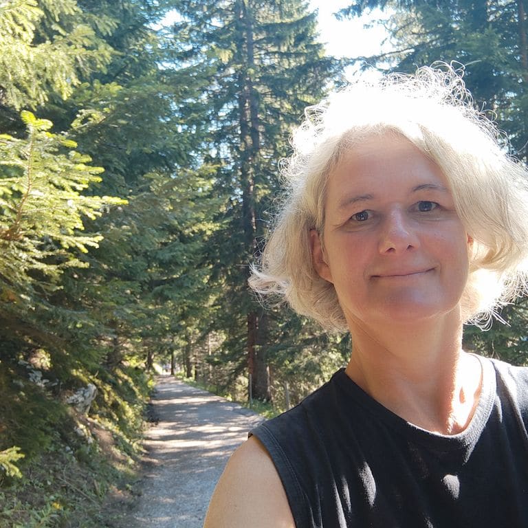 Ute Marth auf einem sonnigen Waldweg
